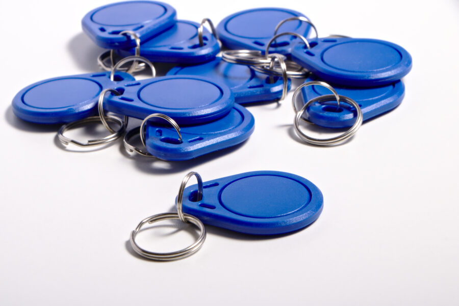 Blaue Plastikkarten mit Metallringen, die auf einer wei&szlig;en Oberfl&auml;che liegen.