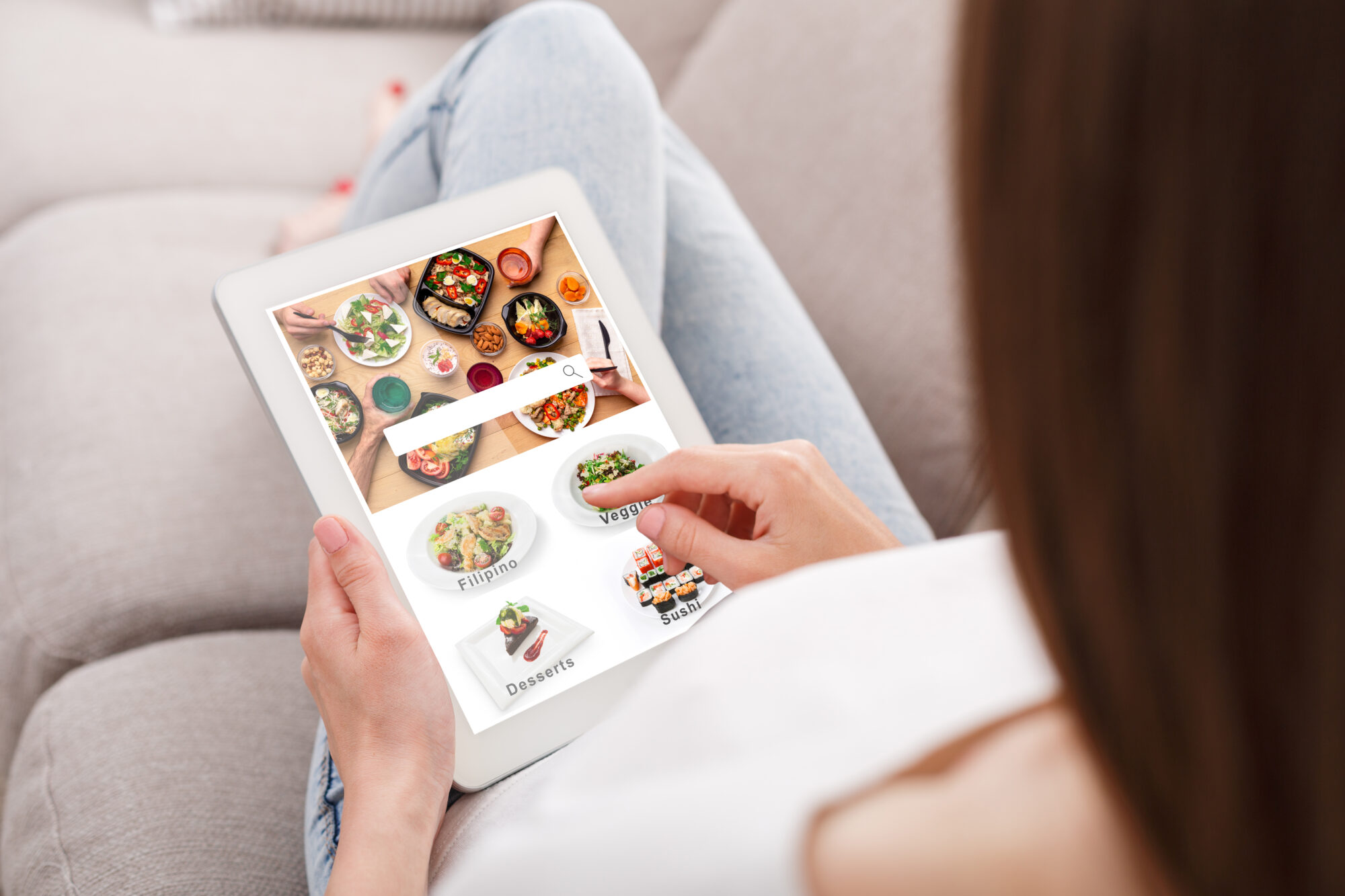 Eine Person, die auf einem Tablet mit Rezepten f&uuml;r verschiedene K&uuml;chenarten browsed.